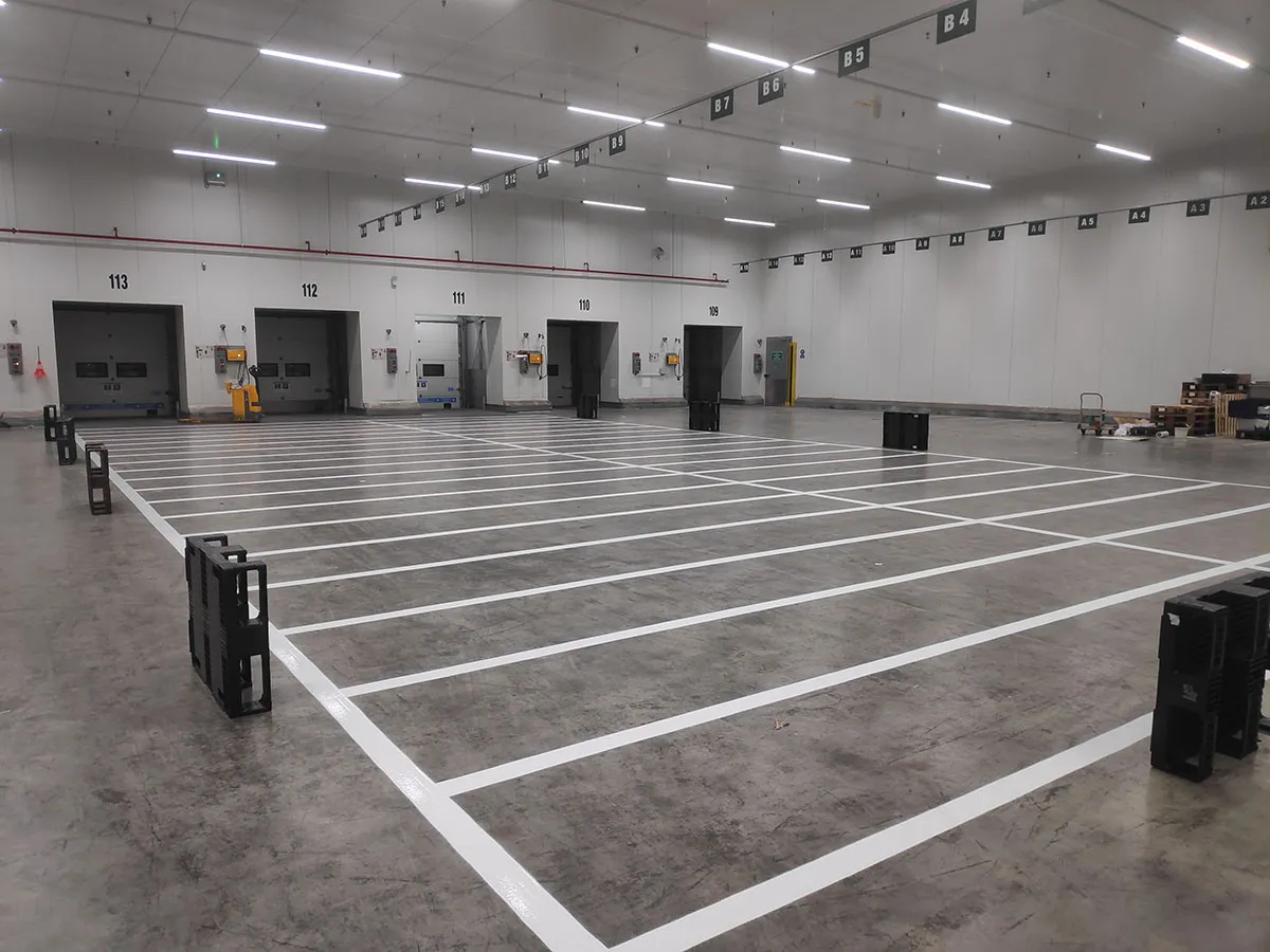 Emplacements logistiques délimités par des lignes blanches devant des quais intérieurs