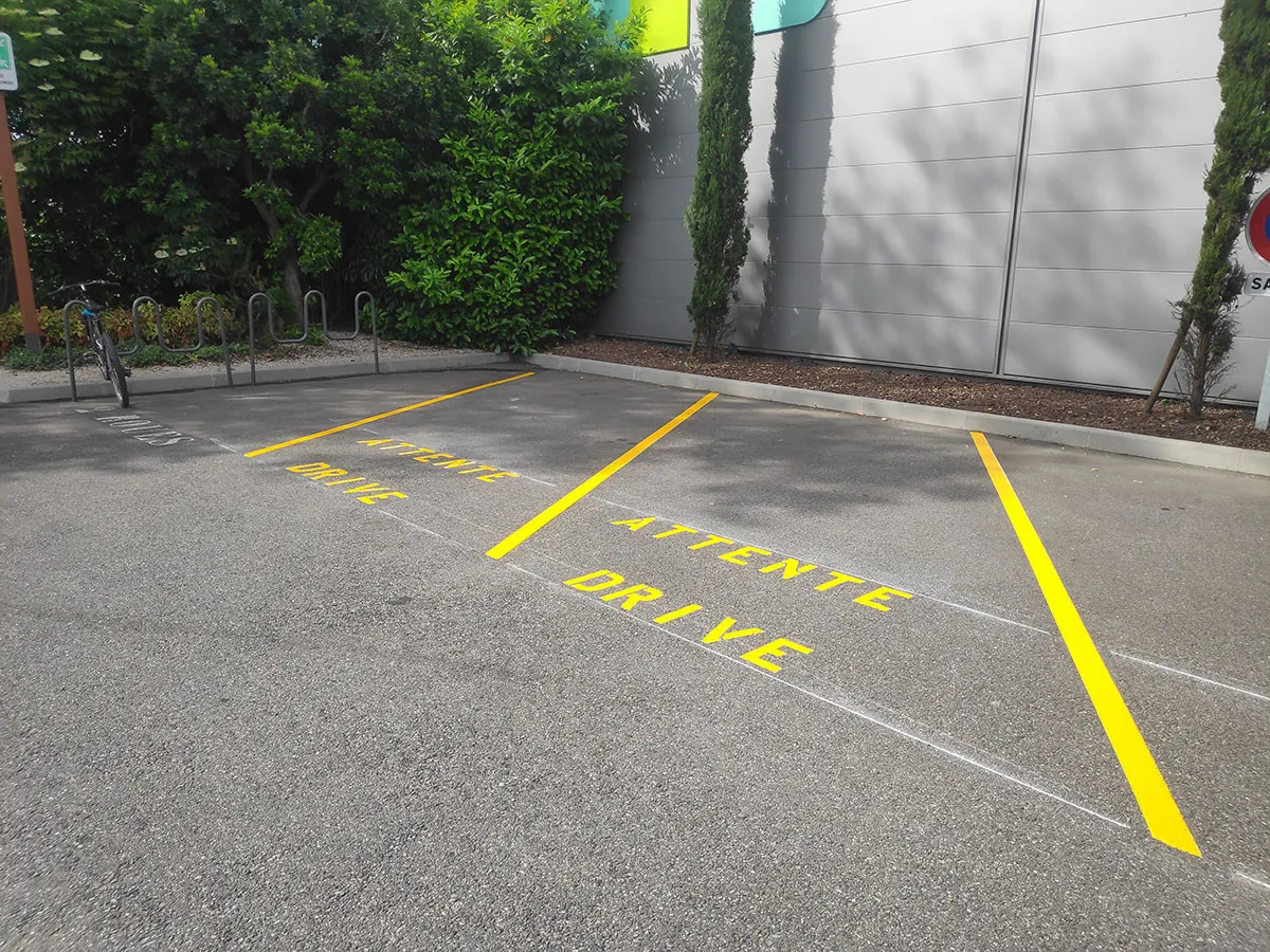 Deux emplacements d’attente délimités en jaune devant un rack à vélos