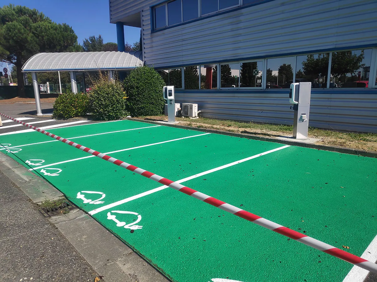 Places vertes réservées aux véhicules électriques devant des bornes de recharge